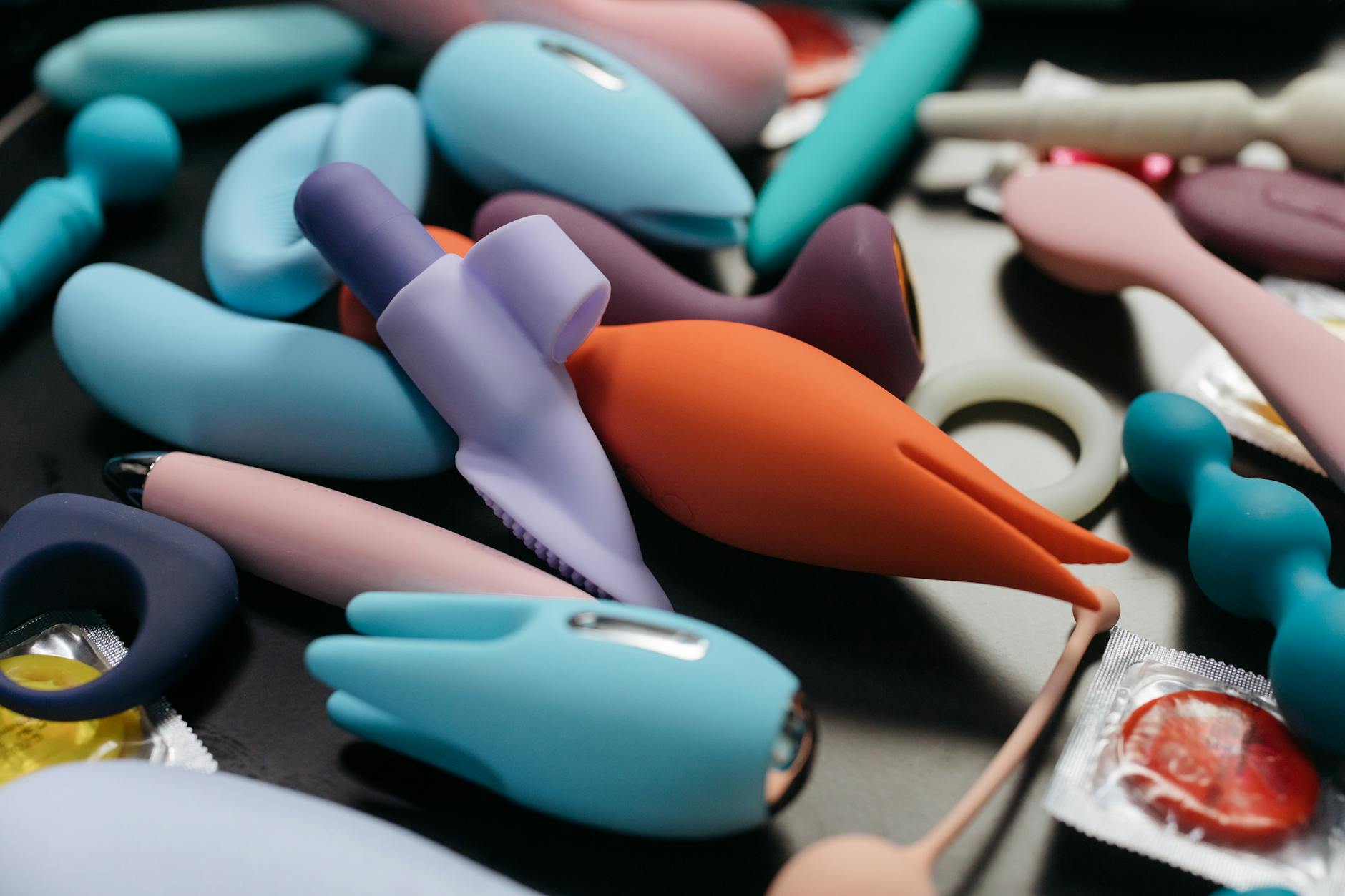Hand holding a vibrator against a minimalist purple backdrop